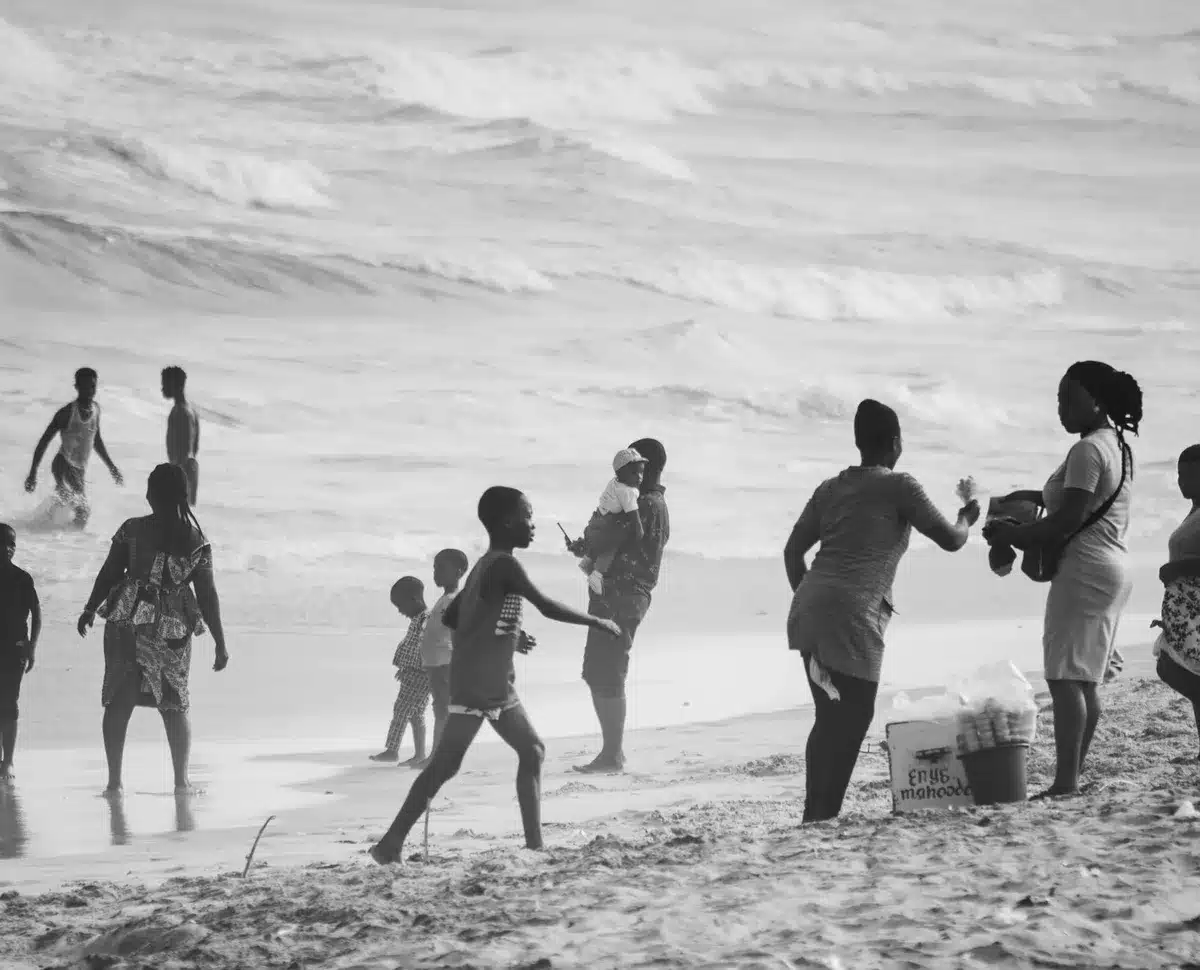 Une famille jouant ensemble sur la plage avec des jeux de sable et un parasol