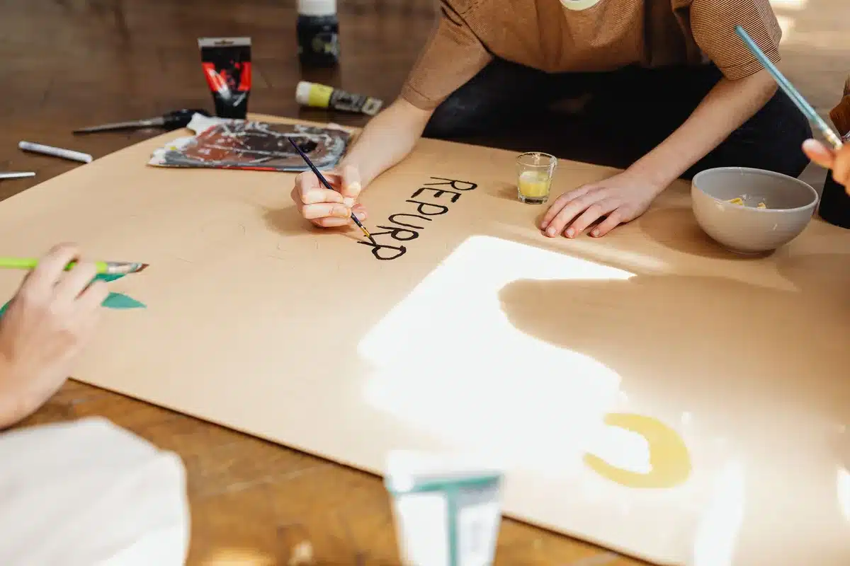 Une famille participant à un atelier créatif autour d'une table, peinture et matériaux visibles
