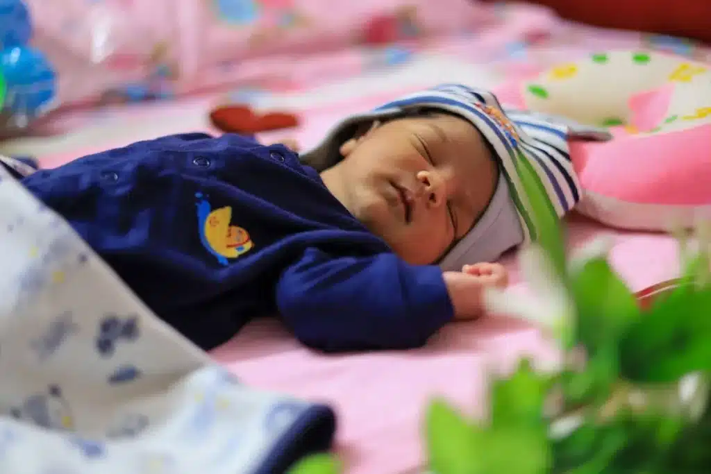 Bébé endormi dans un lit de voyage avec des objets réconfortants familiers