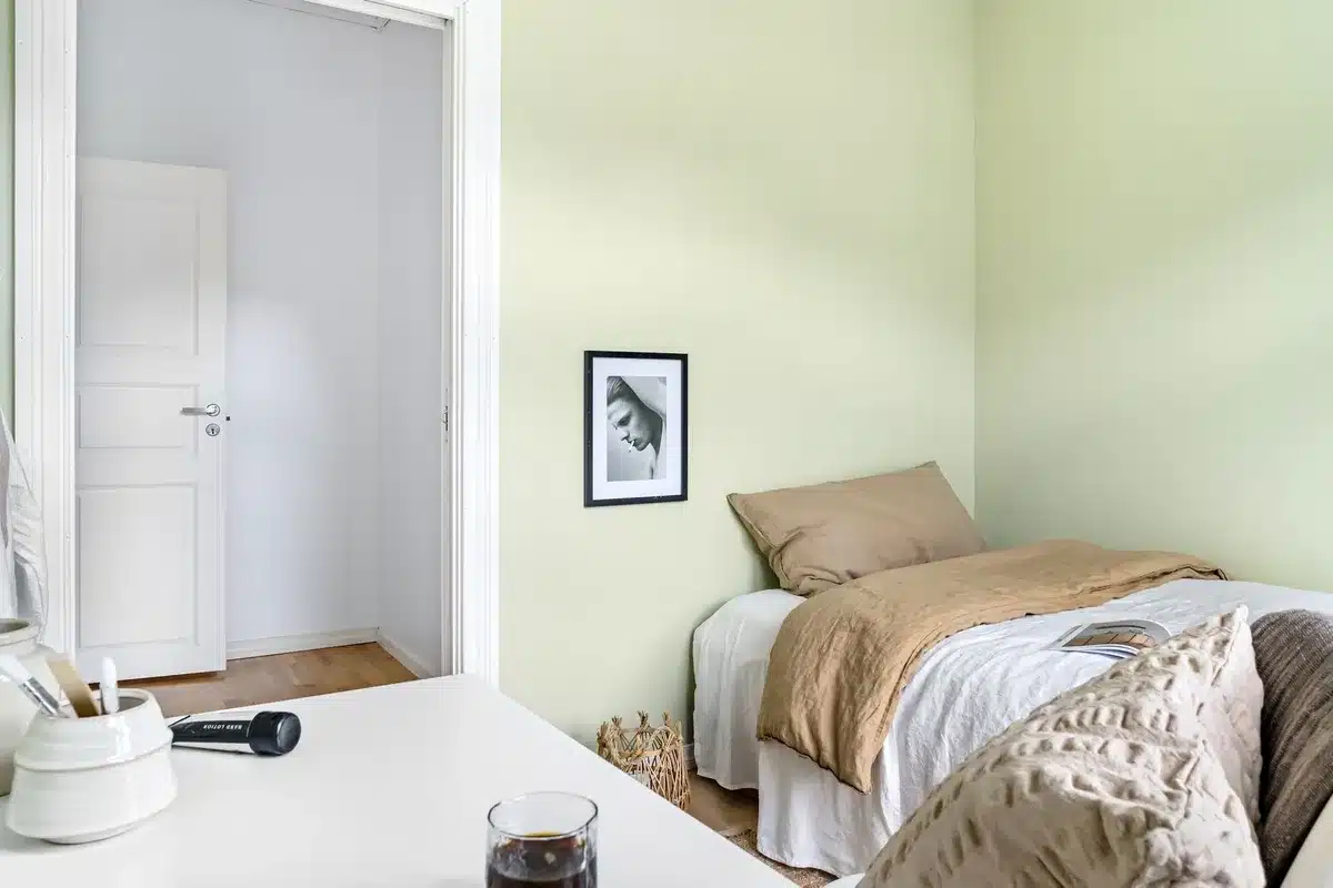 Mur peint en vert d'eau clair dans une chambre d'enfant avec mobilier simple