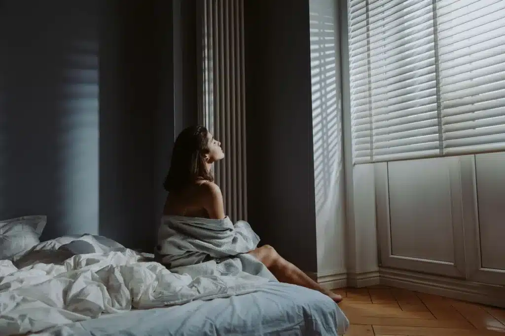 Personne assise seule près d'une fenêtre par un matin gris de janvier, l'air préoccupée