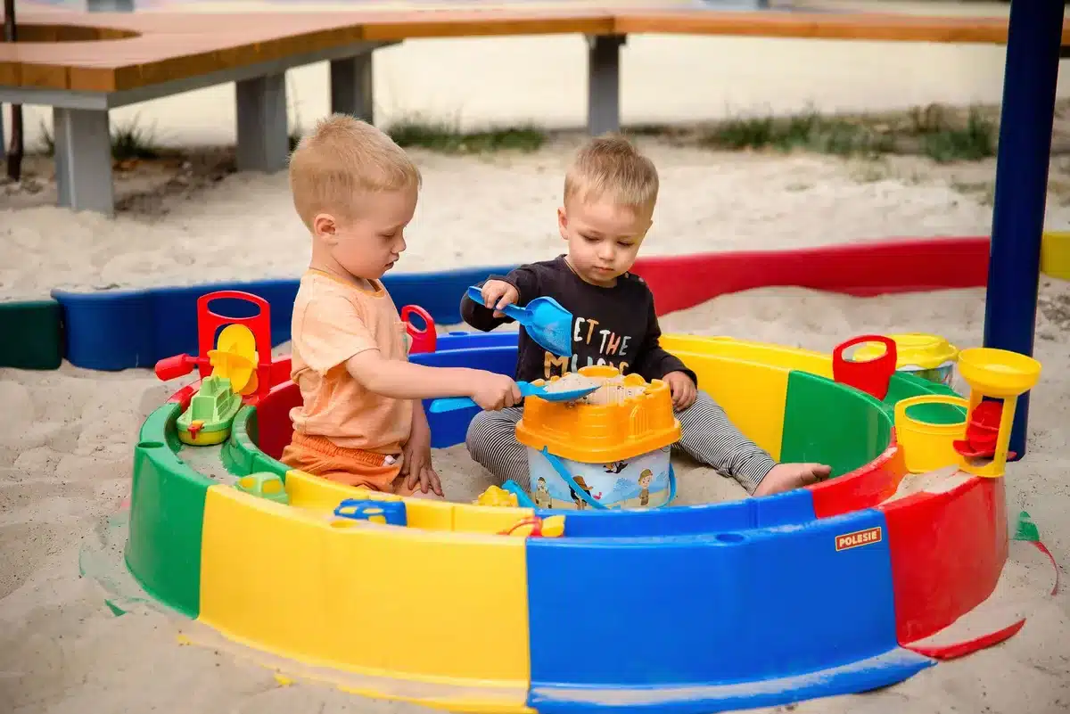 Enfants collaborant ensemble pour construire un château de sable.