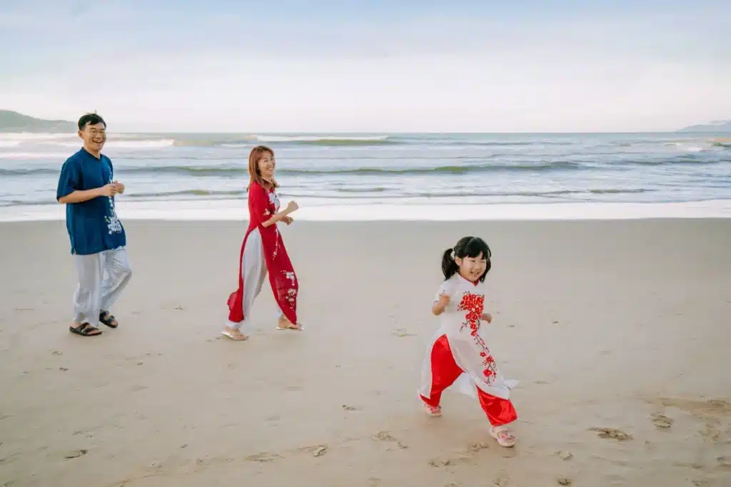 Enfants en dispute pendant les vacances en famille à la plage, parent intervenant calmement.