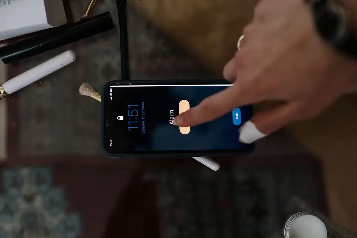 Un téléphone affichant des notifications sur une table de nuit le matin