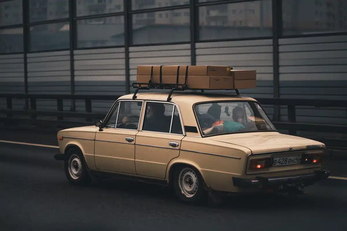 Famille préparant un road-trip en voiture avec bagages et équipements