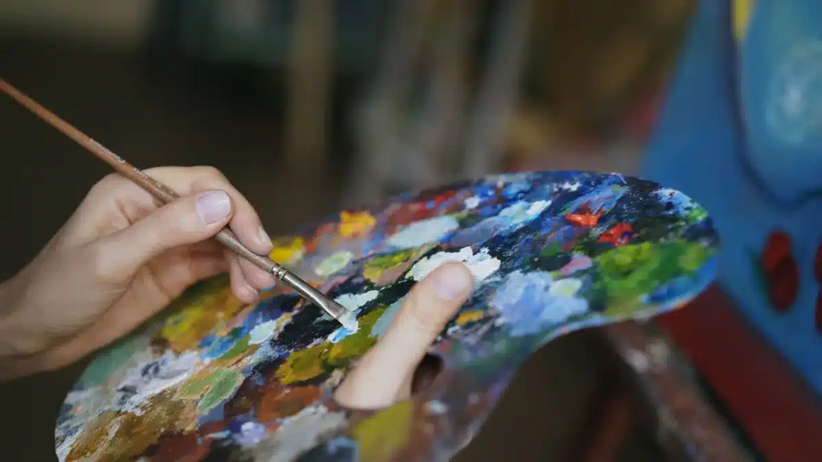 Palette de peintre avec différentes teintes montrant comment la lumière interagit avec les couleurs