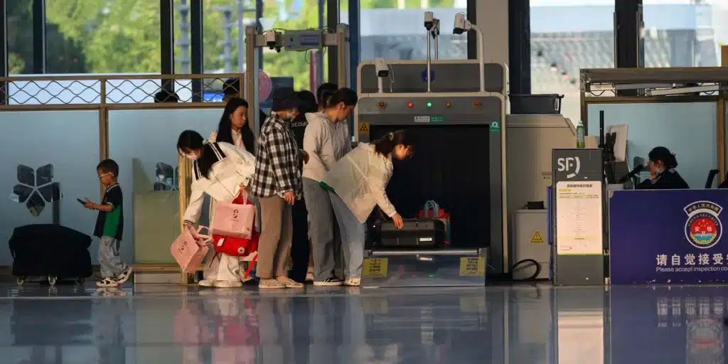 Voyageur passant le contrôle de sécurité à l'aéroport avec bagages et documents