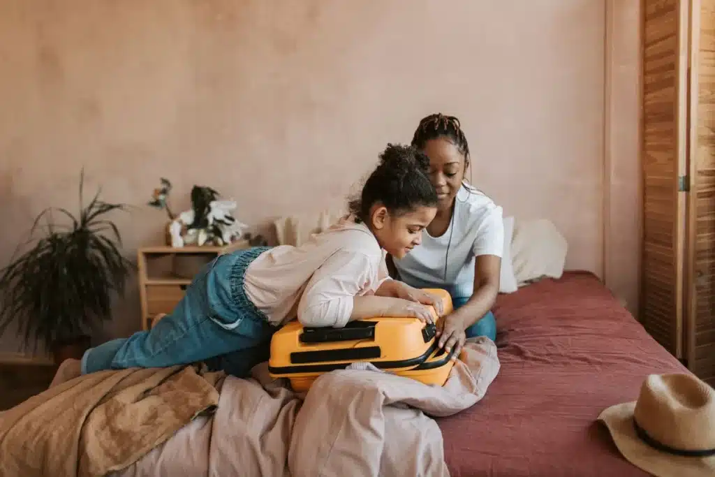 Préparation méthodique d'une valise avec affaires de bébé et documents de voyage