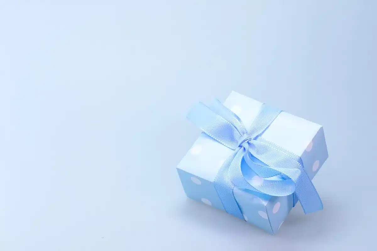Emballage réutilisable en tissu pour un cadeau de naissance présenté avec soin