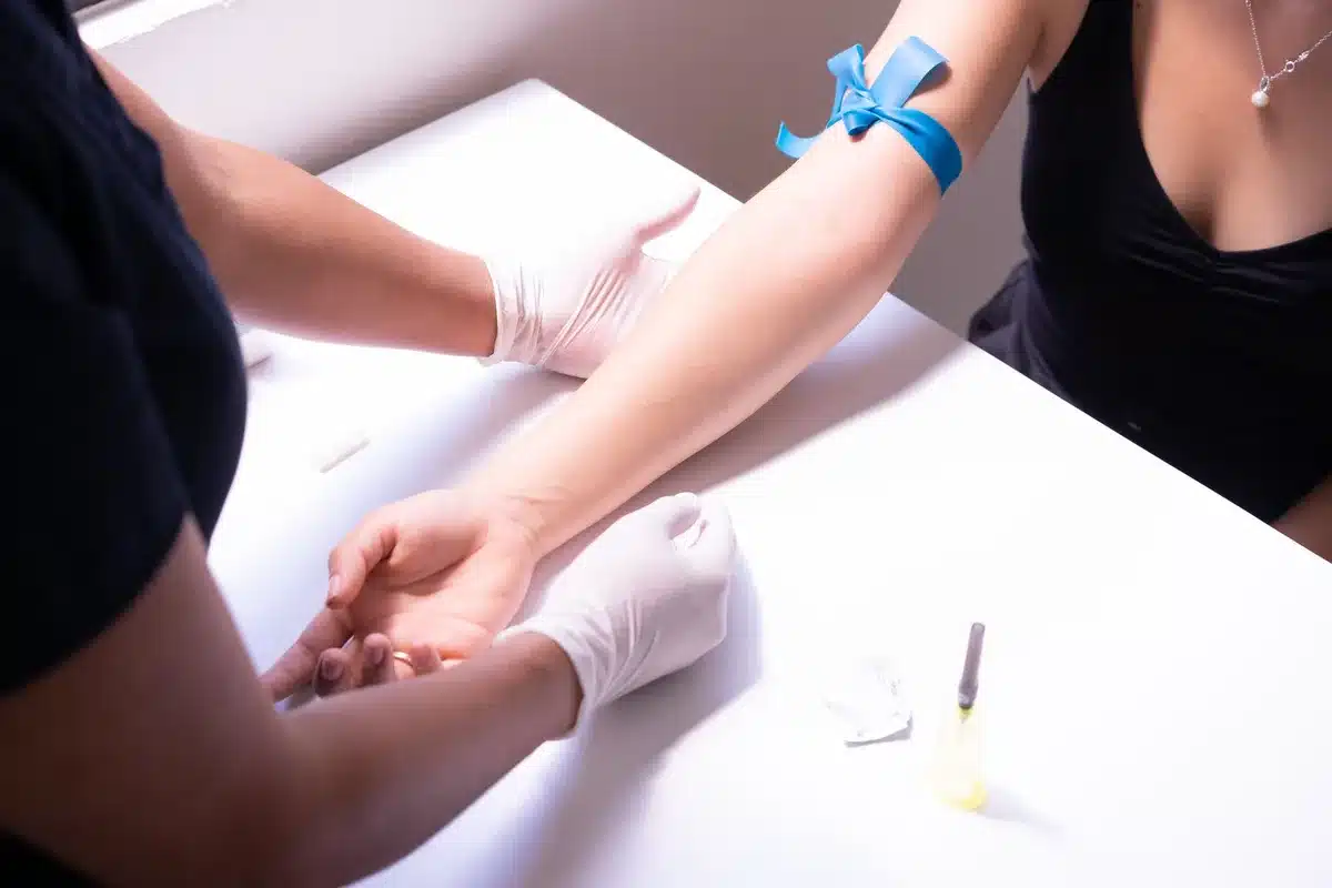 Prélèvement sanguin effectué par un professionnel de santé en laboratoire médical.