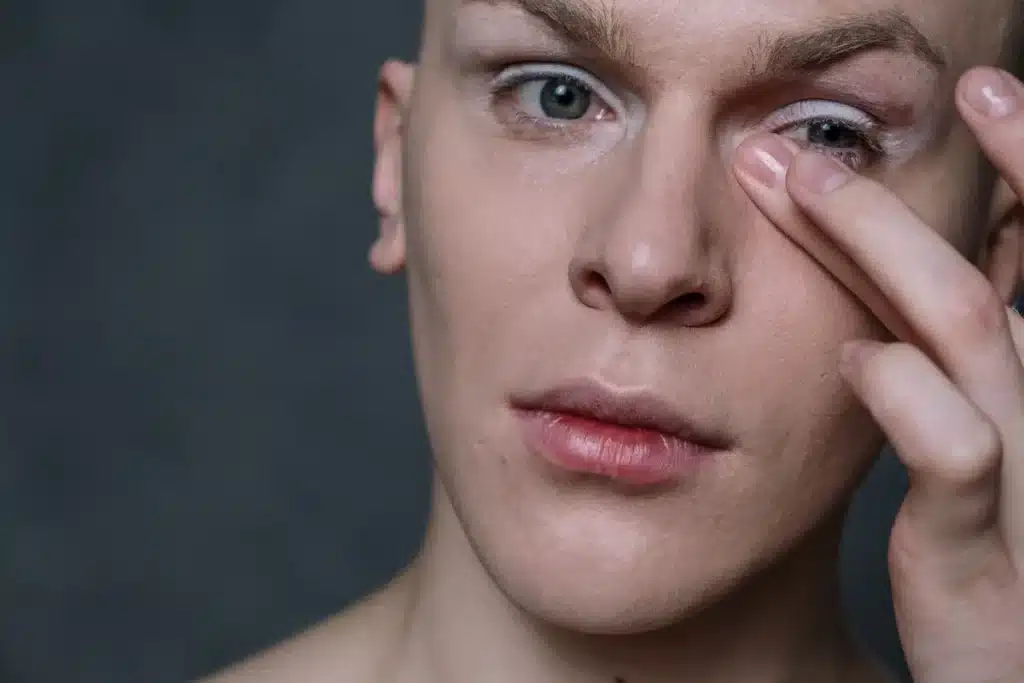 Application douce d'un soin contour des yeux avec le bout des doigts sur la zone péri-orbitaire