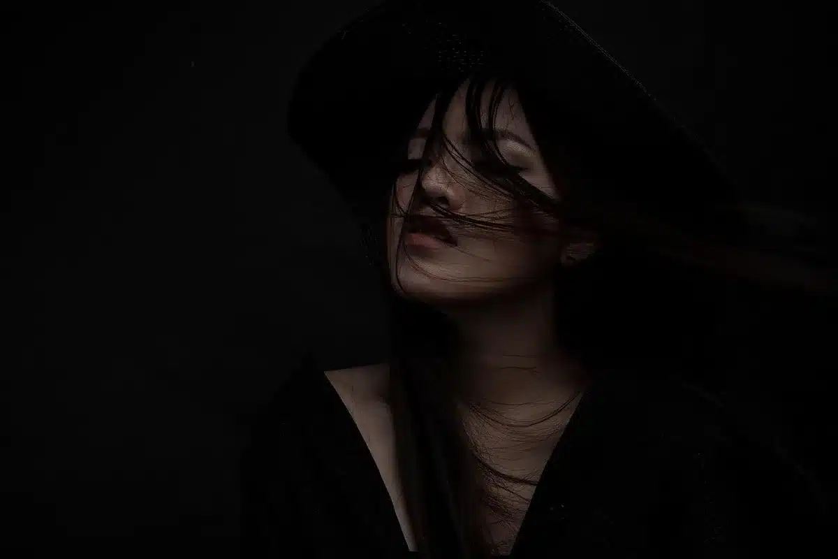 Femme en robe noire sobre et bien coupée, regard serein