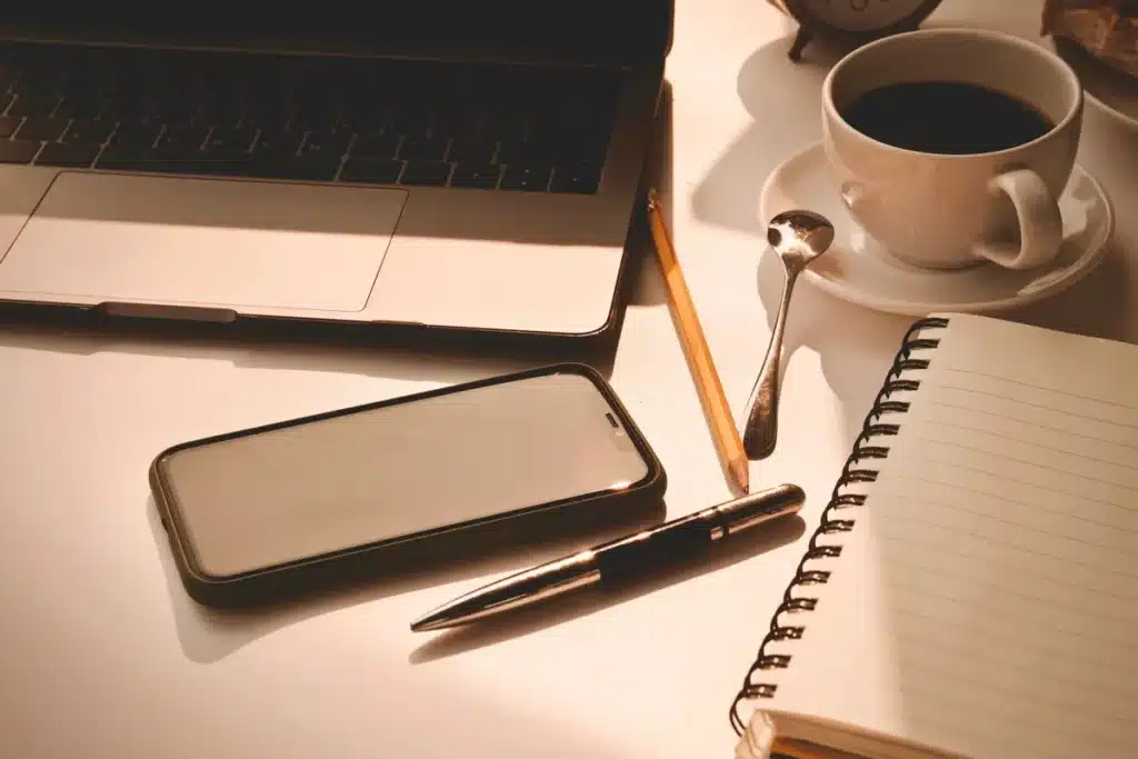 Personne au bureau avec une tasse de thé, des fruits frais et des oléagineux en lumière matinale