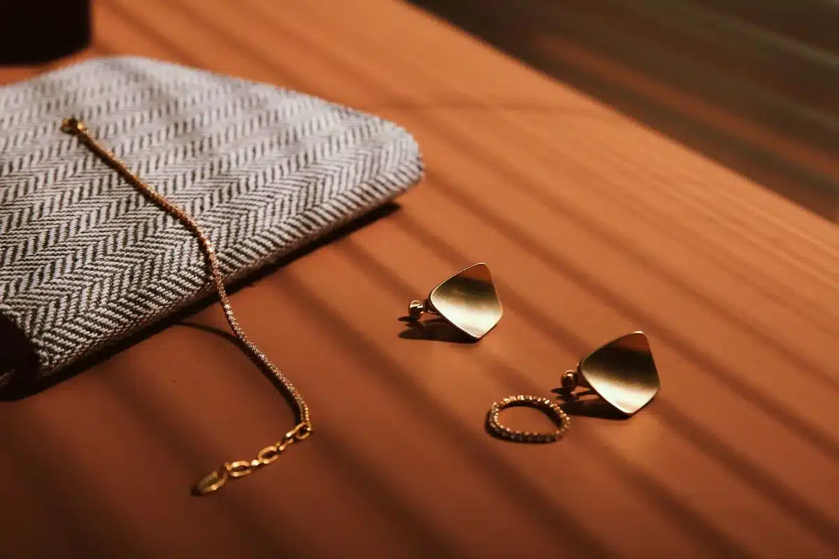 Détail d'accessoires de mariage : pochette, boucles d'oreilles et bijoux discrets sur une tenue élégante.