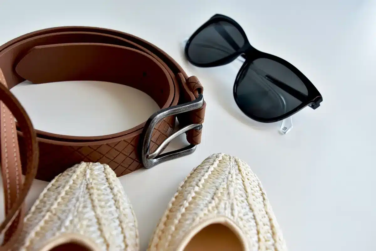 Écharpe, ceinture et chaussures disposées sur une table comme touches de tendance