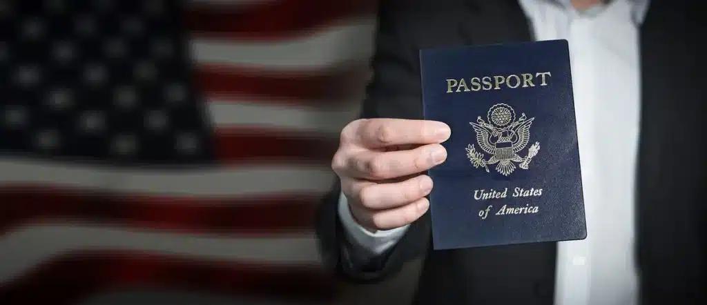 Passeport et formulaires de demande de visa posés sur un bureau, mains préparant des copies
