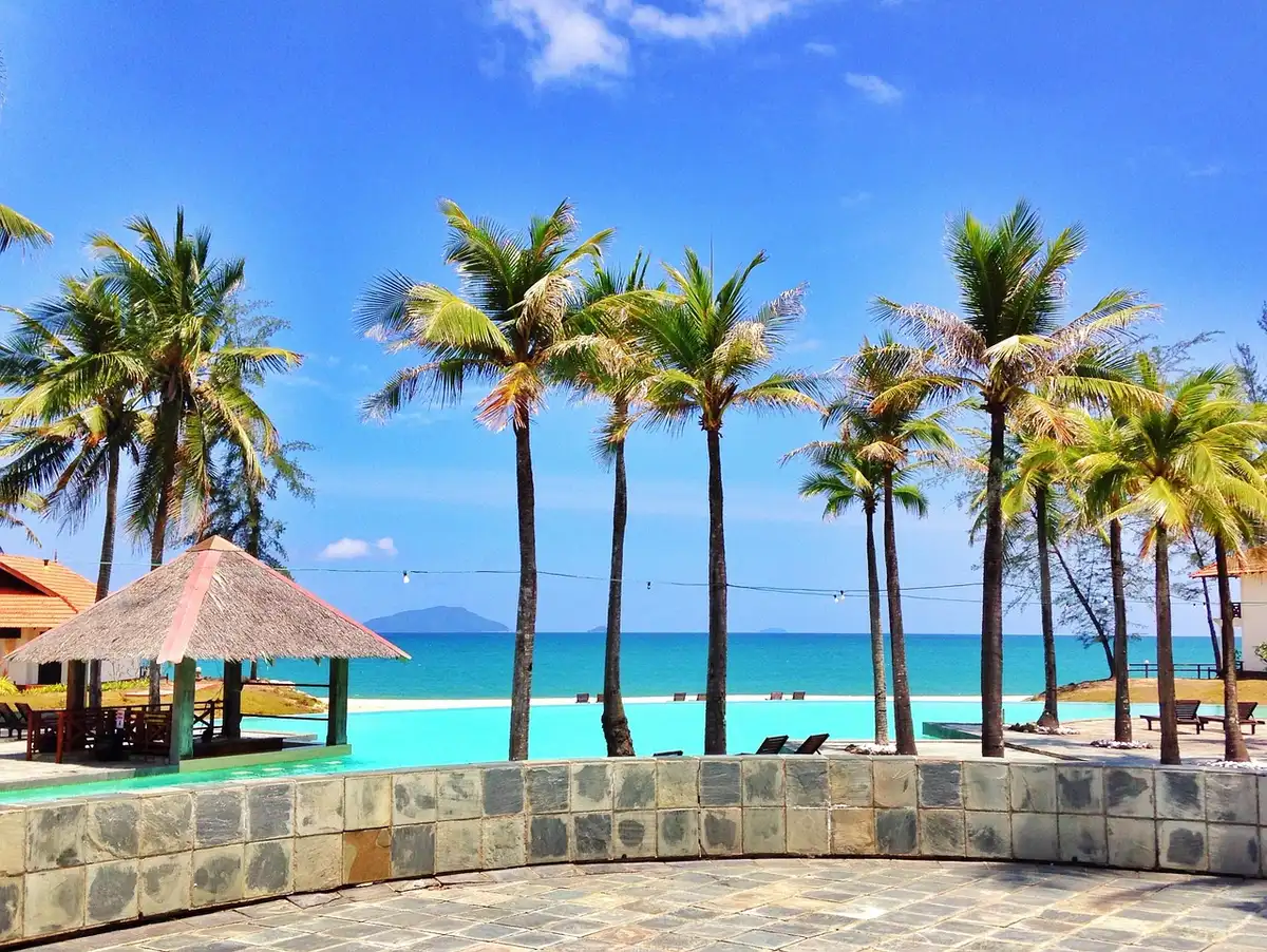 Plage de sable blanc avec eaux turquoise et palmiers en Jamaïque