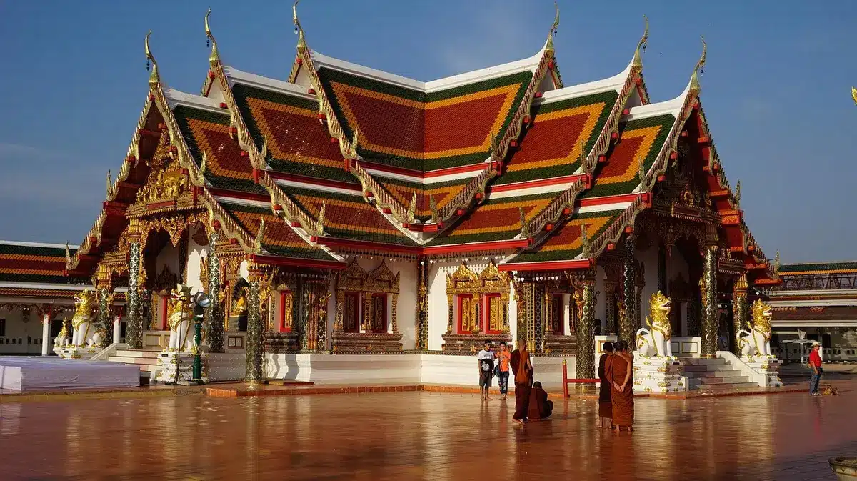 Petit sanctuaire et offrandes sur un trottoir de Bangkok en plein jour