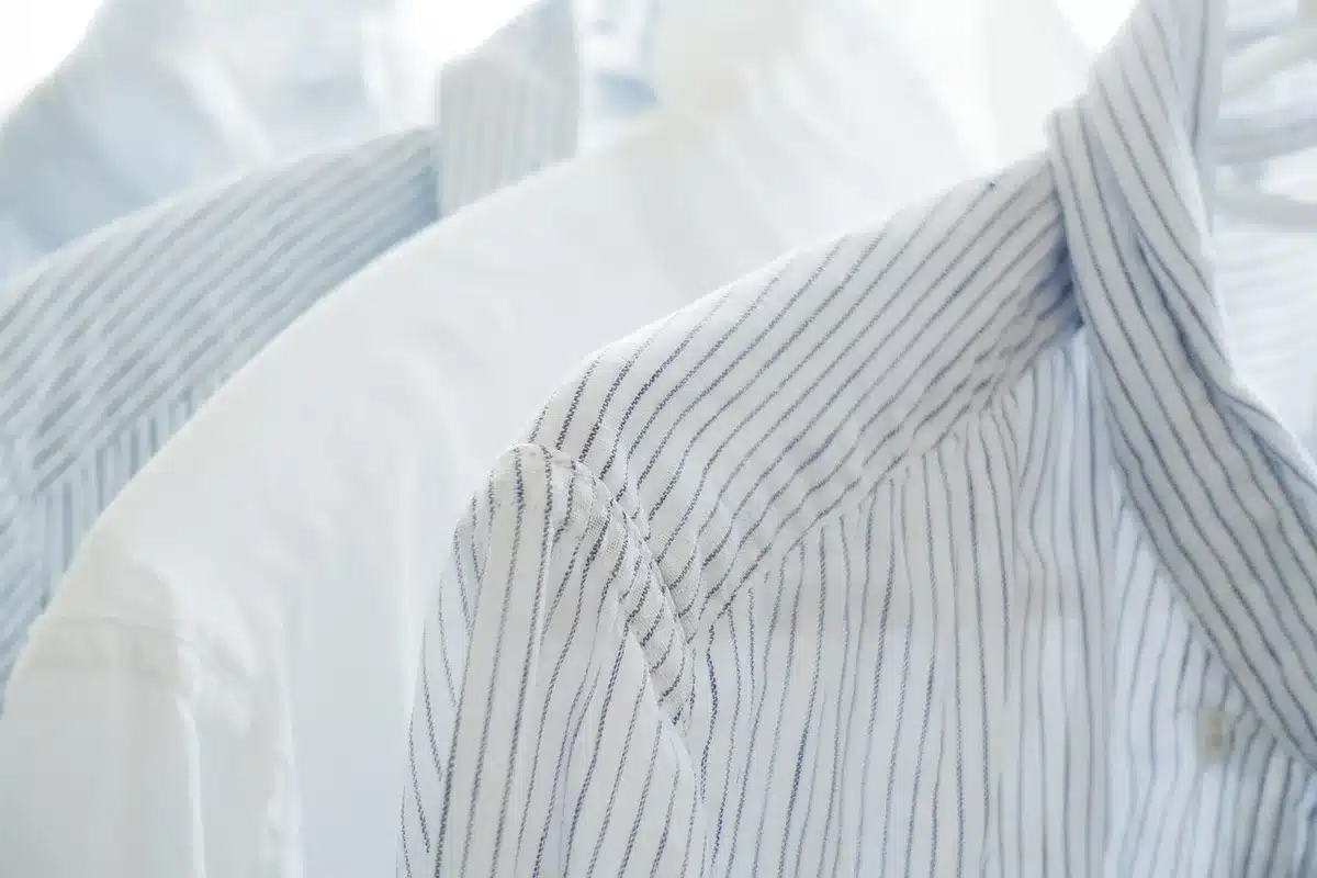 Femme portant un maillot de bain blanc avec une chemise en lin légère et accessoires d'été.