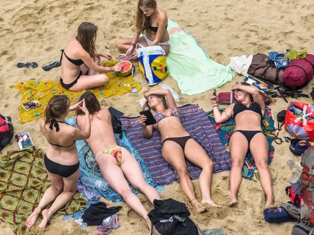 Sélection variée de maillots de bain été 2026 avec imprimés pois, blanc minimaliste et détails métallisés sur fond de pl