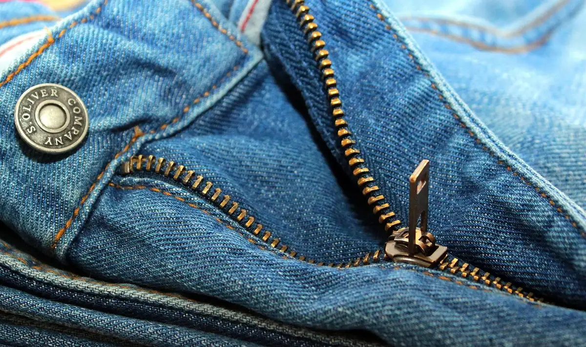 Gros plan sur la texture d'une toile denim structurée, illustrant la matière idéale pour un pantalon bouffant.