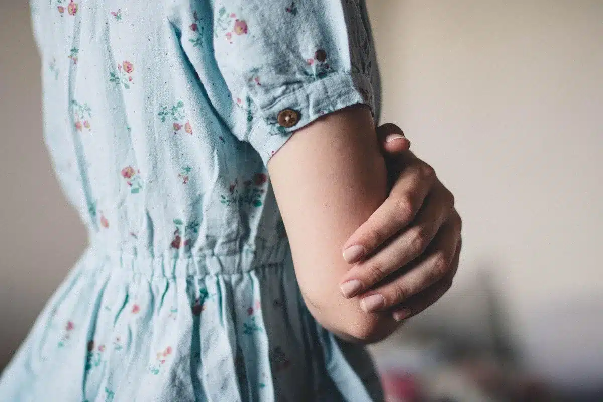 Gros plan sur les détails de couture : smocks, plissés et dentelle sur une robe