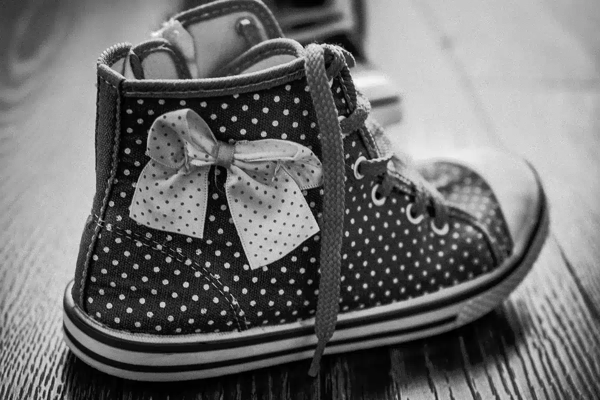 Différents types de chaussures posés au sol : baskets, mocassins, slingbacks