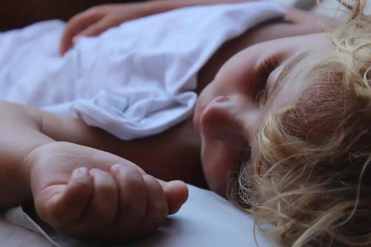 Un enfant endormi lors d'une sieste en collectivité, dans un environnement sécurisé