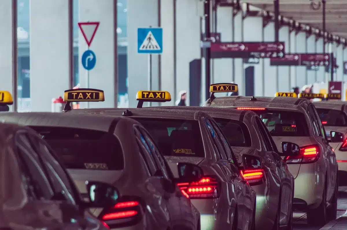 Passagers chargeant des bagages dans le coffre d'un taxi adapté