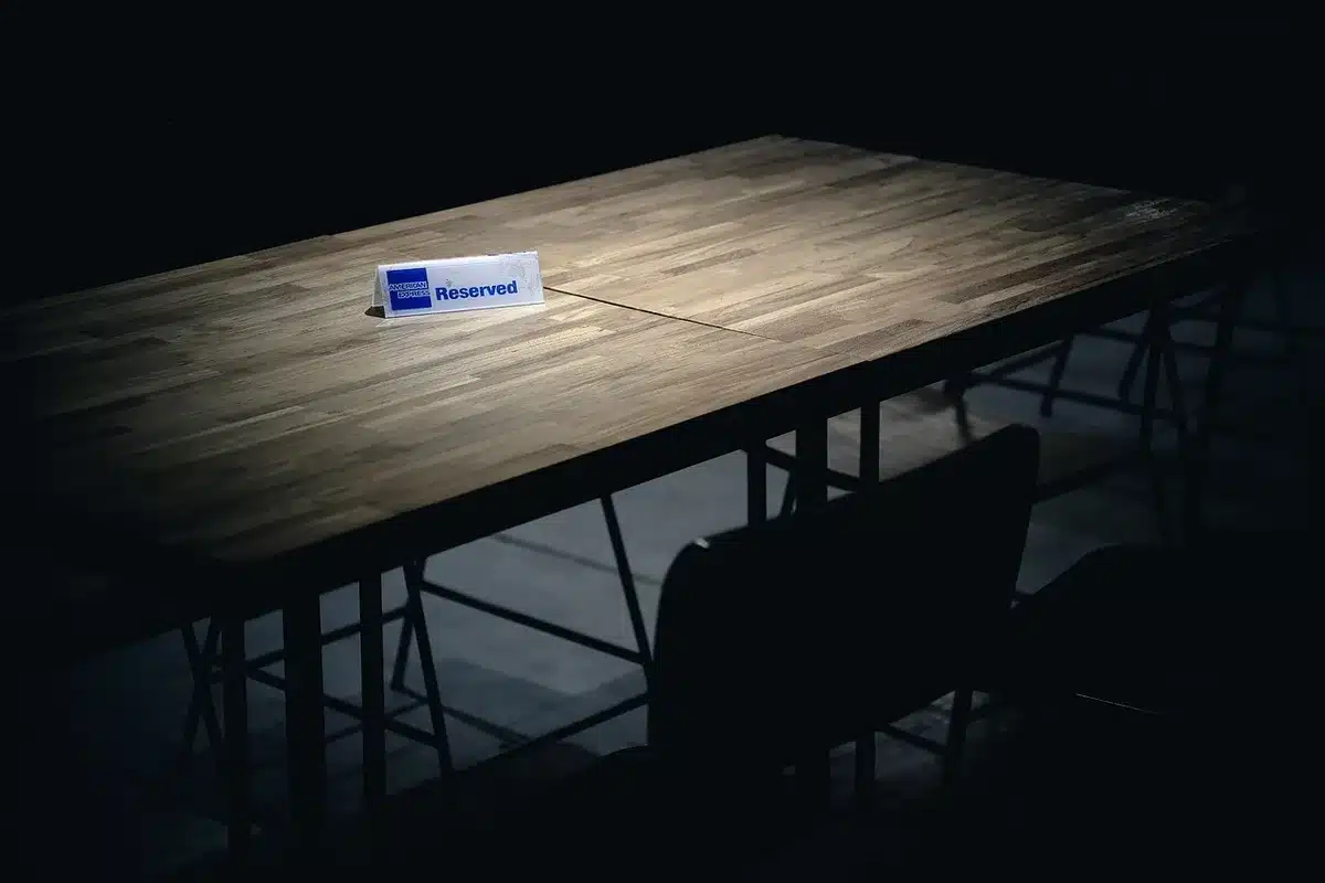 Salle commune d'un gîte avec grande table prête pour un repas de groupe